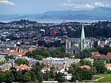 Luftbild einer Stadt, die an einem Gewässer liegt. Zentral im Bild befindet sich der Dom von Trondheim.