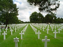 A photograph of white grave markers on green grass at the Normandy American Cemetery and Memorial near Omaha Beach in France