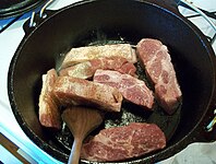 Browning the meat in a cast-iron pot