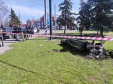 Debris from one of the missiles, with the railway station visible in the background. The top half of the inscription ZA DETEI ("[in revenge] for the children") is visible. Kramatorsk railway bombing 2022 April 8 (9).jpg