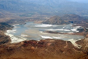 Das etwa 20 km² große Gelände mit dem Las Tórtolas-Absetzbecken wie es nur aus der Luft gesehen werden kann. Vom Boden aus, in der Umgebung, sind praktisch nur die umgebenden Berge und Dämme sichtbar. Auf der anderen Seite der angrenzenden höheren Berge liegt die 150.000 Einwohnerstadt Colina.