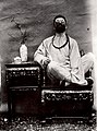 Auguste François déguisé en fumeur chinois avec une fausse tresse (1896).