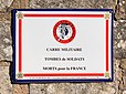 Une plaque émaillée de l'association Nationale du Souvenir Français indiquant la présence d'un carré militaire au sein d'un cimetière avec des tombes de soldats morts pour la France.