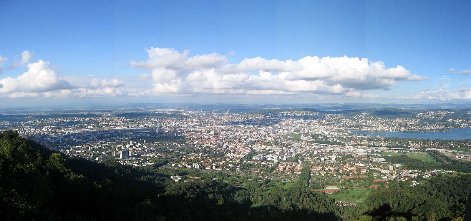 Celkový pohled na město z hory Uetliberg; Curyšské jezero vpravo