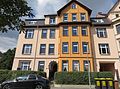 Mietshaus in ehemals geschlossener Bebauung mit Einfriedung und Vorgarten