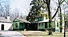 light green and white building, large tree in foreground