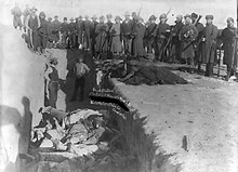 Mass grave of Lakota dead after the 1890 Wounded Knee massacre. Wounded Knee 1891.jpg