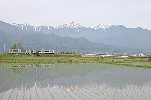 北アルプス連峰を背景にして 安曇野市の田園地帯を走る電車 （2005年5月8日）