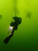 Diver deploying a decompression buoy while ascending from the wreck