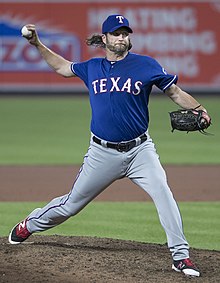 Un joueur de baseball portant un maillot sur lequel est écrit Texas, lance une balle.