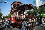 Festival float with attached small roofed stage and dolls