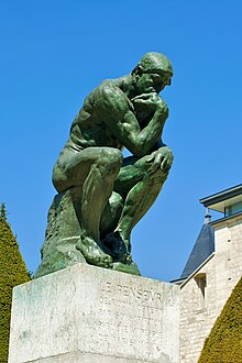 Estatua de bronce de un hombre sentado, pensando