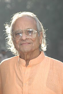 Photograph of an old man wearing glasses.