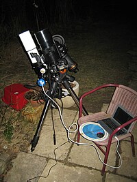 An amateur astrophotography setup with an automated guide system connected to a laptop Starwatching.jpg