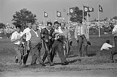 John Surtees wordt ondersteund na zijn val in de vierde ronde.