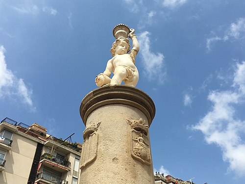 Columna toscana amb dos dels quatre escuts, el de l'antic municipi de Sants i el de Catalunya