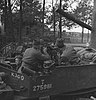 Militairen van de Prinses Irene Brigade in een Bren Gun Carrier. Twee van hen dragen een mutsdas. De chauffeur draagt een baret en de achterste man een Brodie-helm (1944)