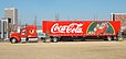 Camion Coca-Cola (le tracteur est de marque Peterbilt, modèle Peterbilt 379) devant le "World of Coca-Cola" à Atlanta à l'approche de Noël, avec, au fond à gauche, le siège mondial de Coca-Cola.