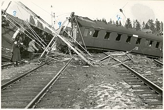 Bilden visar skadade vagnar och nedriven kontaktledningsbrygga.