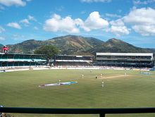 A cricket ground with mountains in the background.