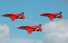 The RAF Red Arrows depart the 2014 Royal International Air Tattoo, England, in a colour scheme that commemorates their 50th year. RAF Red Arrows depart RIAT Fairford 14thJuly2014 arp.jpg