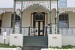 A double-storeyed house with iron roof and windows of 19th century. Its ornate veranda is similar to that of no 3.".