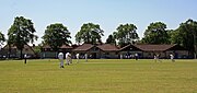 Cricket being played in front of the pavilion at Knowle Cricket Club Ground