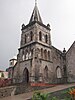 Western end of Roseau Cathedral with a tower capped by a steeple and white marble statues in three niches above the door