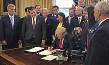 Smith looks on as President Donald Trump signs the NASA Transition Authorization Act of 2017 Transition Authorization Act Signing.jpg