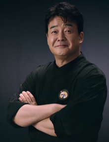 Coloured portrait of South Korean Chef, Baek Jong-won, with his arms crossed