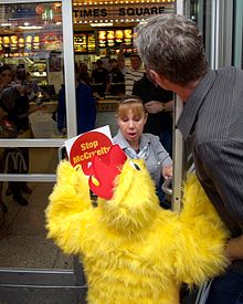 A PETA activist dressed as a chicken confronts the manager of the Times Square McDonald's over the company's animal welfare standards. Centerfold Stripper Midgets Chickens 39 2010 Shankbone.jpg