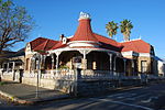 This richly ornamented Victorian, house is one of the so-called "ostrich palaces" and was designed by the well known architect Charles Bullock. It was erected during 1909/10 for J. H. J. le Roux of the farm Baakenskraal at a stage when the ostrich feather industry was its peak.