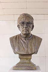 Popiersie przedstawiające mężczyznę w okularach na białym tle