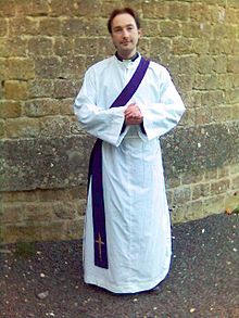 A deacon vested in an alb with a stole over the left shoulder Stoledeacon.jpg