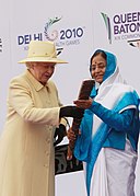 Isabel II pasando el relevo a la presidenta Patil de la India durante el relevo de los Juegos de la Mancomunidad de Delhi, 2009