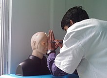 Uno studente di medicina esegue una visita oculistica su un manichino a Mauritius.