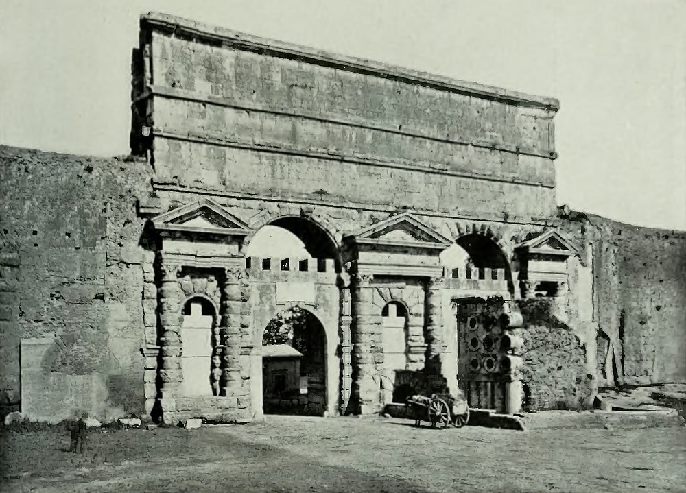 A gate in the walls of Rome carrying aqueducts on top.