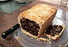 A black bun cut open to reveal the fruitcake filling