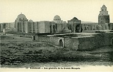 Photographie d’époque de la Grande Mosquée de Kairouan, montrant la façade méridionale et orientale ainsi que le minaret.