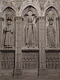 L'évêque, Pierre de Rochefort, entouré de ses diacres. Monument funéraire surplombant sa dalle mortuaire visible dans la basilique Saint-Nazaire.