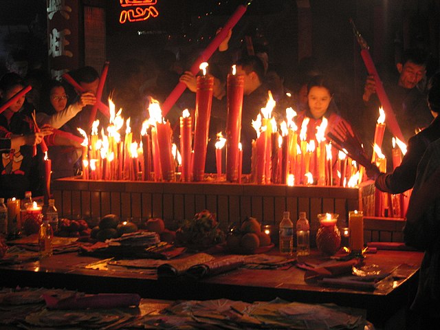 Chinese New Year eve in Meizhou at eastern Guangdong province, China. Fireworks are set off to ward off the bad spirits from the previous year and welcome the new year in. Candles and incense are also lighted during prayers, like this scene on Chinese New Year's Eve.