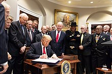 Portnow (to the left of US President Donald Trump) as the Music Modernization Act is signed into law in 2018 President Donald J. Trump signs the Music Modernization Act (45200025962).jpg