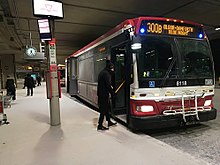 A passenger boards an Orion VII bus owned and operated by the TTC in Toronto Pearson International Airport. The TTC operates the third-largest fleet of buses in North America. Ttc-300B-pearson.jpg