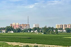 A picture from a relatively big distance, showing the view of the Shenqui County. Grass and tall buildings visible