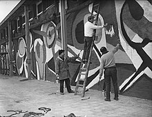 Cobra member Karel Appel working on a mural in Rotterdam for the Manifestation E55 Aanbouw tentoonstelling E55 Rotterdam, Bestanddeelnr 907-0826.jpg