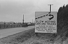 This sign, photographed in 1941 on US 99 between Seattle, Washington, and Portland, Oregon, illustrates one rationale for a federal highway system: national defense. Highway Sign.jpg