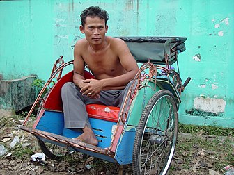 Un conducteur de becak à l'entrée de la ville de Jakarta, en Indonésie. (définition réelle 2 560 × 1 920)