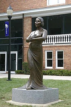 This eight foot bronze sculpture was erected on 09/11/2006 in front of Twichell Auditorium on the campus of Converse College in Spartanburg, South Carolina. Designed by NY-based artist Meredith Bergmann and commissioned by the college; the sculpture is housed permanently on the campus.