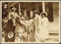 Thorpe shaking hands with Moses Friedman while Glenn "Pop" Warner (left), Lewis Tewanima (center), and a crowd look on