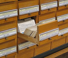 In the 21st century, metadata typically refers to digital forms, but traditional card catalogs contain metadata, with cards holding information about books in a library (author, title, subject, etc.). Schlagwortkatalog.jpg